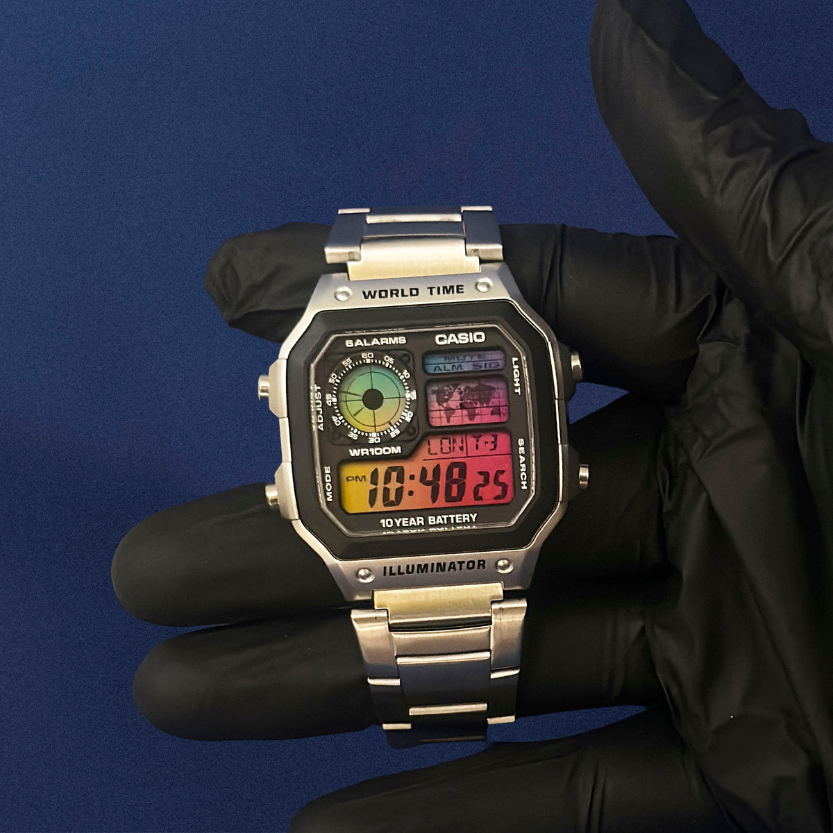 Casio AE-1200 Chromatic Signal teräksisenä kädessä, sateenkaariliuku sinisestä punaiseen, K-Project Labilta