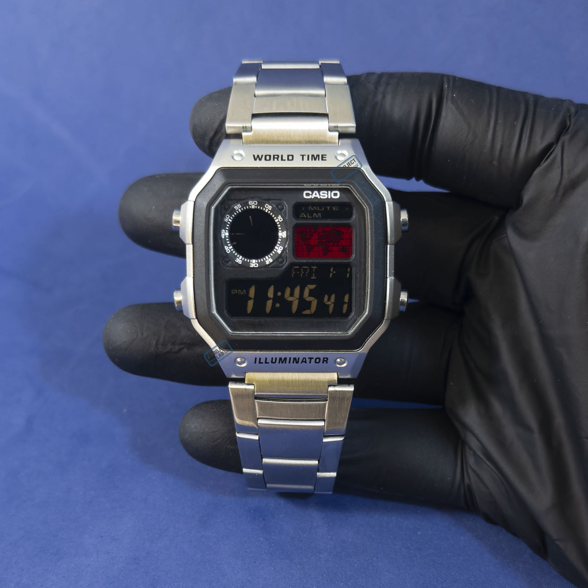 Casio AE-1200 Crimson Meridian in Stahl, in schwarz behandschuhter Hand vor blauem Hintergrund, von K-Project Lab