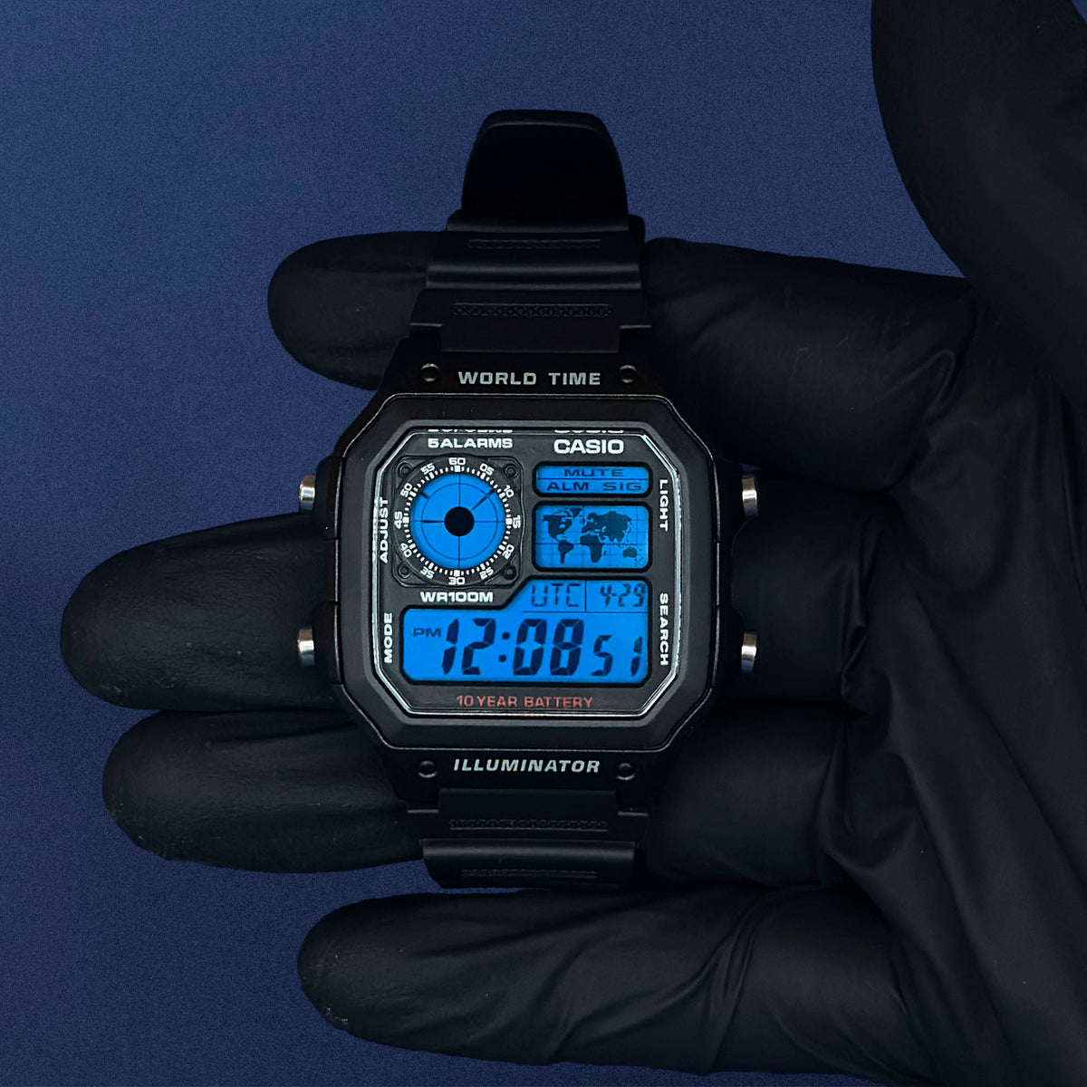 K-Project Labin Casio AE-1200 Deep Blue Grid mustana hartsina, hansikkaassa kädessä, voimakkaan sininen näyttö