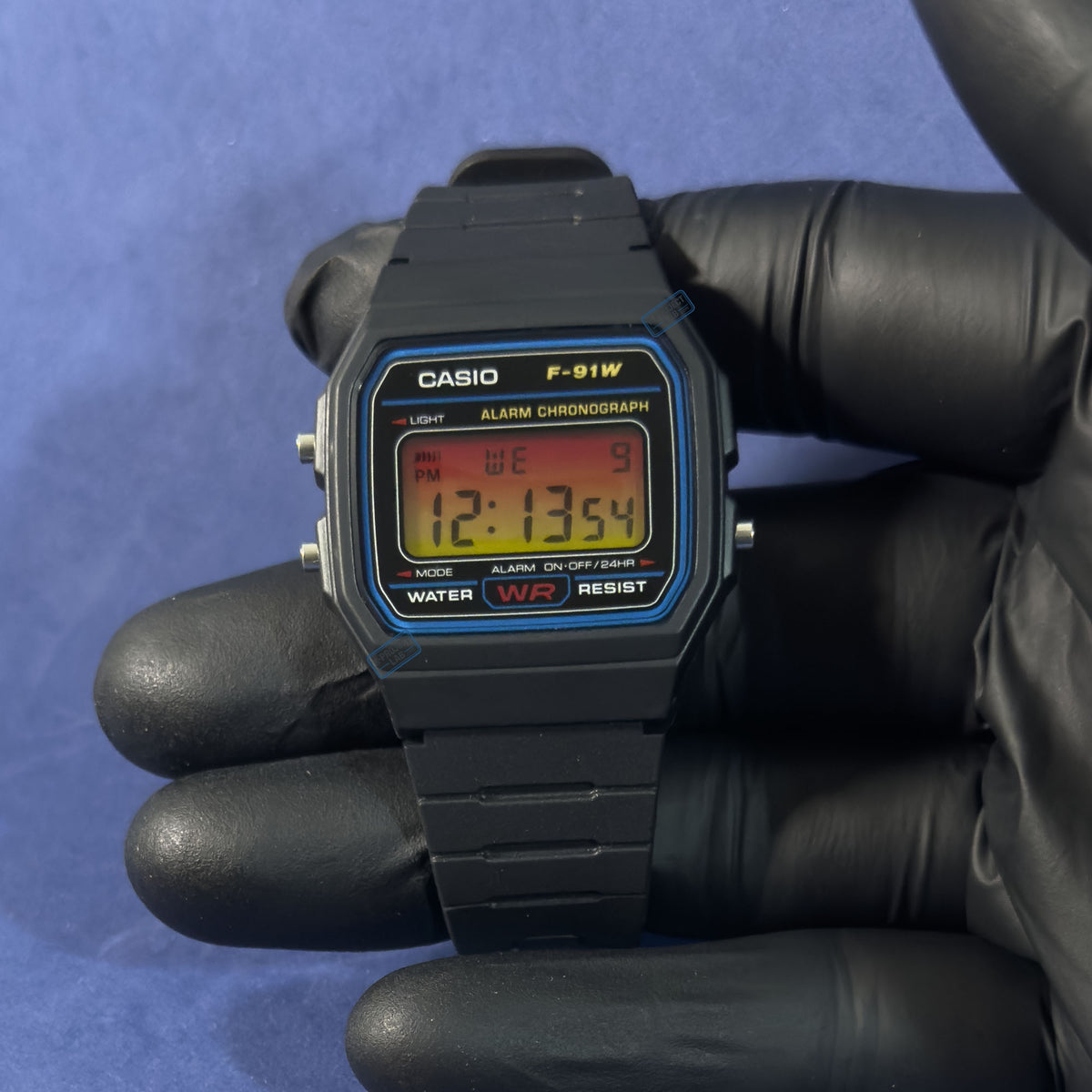 Casio F-91W Solar Horizont in schwarzem Resin, in behandschuhter Hand, rote Ziffern auf warmem Grund, von K-Project Lab