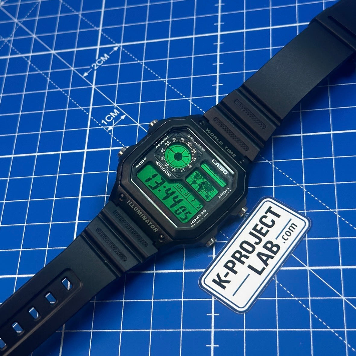 K-Project Labin muokkaama Casio AE-1200 Green Data Terminal mustana hartsina viistosti, vihreä kellotaulu ja näyttö