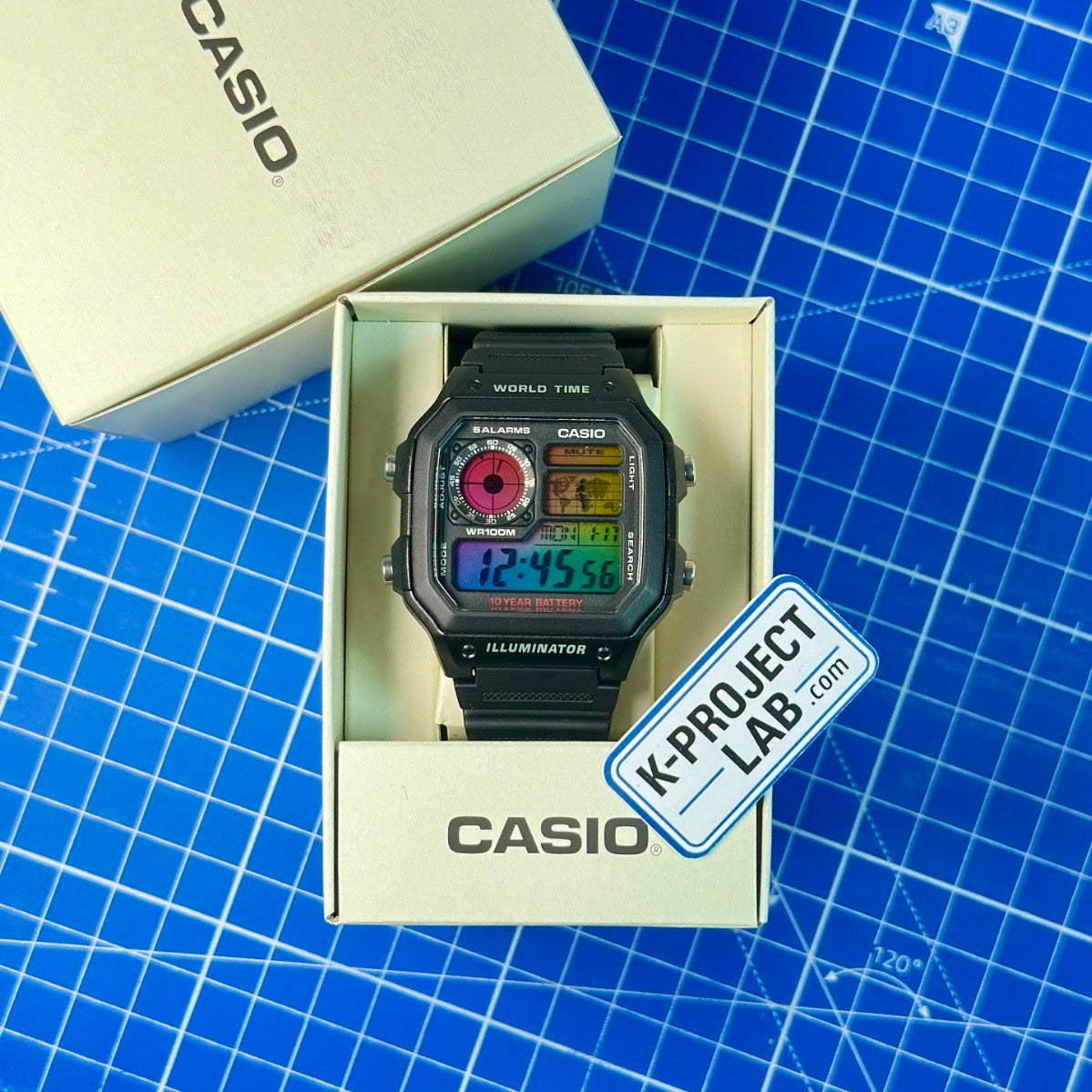K-Project Labin Casio AE-1200 Chromatic Grid mustana hartsina, Casio-rasiassaan sinisellä matolla