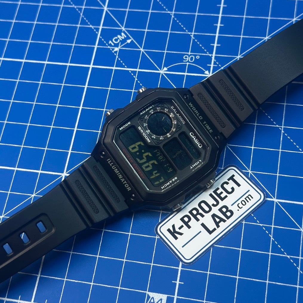Casio AE-1200 Ghost in schwarzem Resin im Winkel auf der blauen Werkstattmatte von K-Project Lab