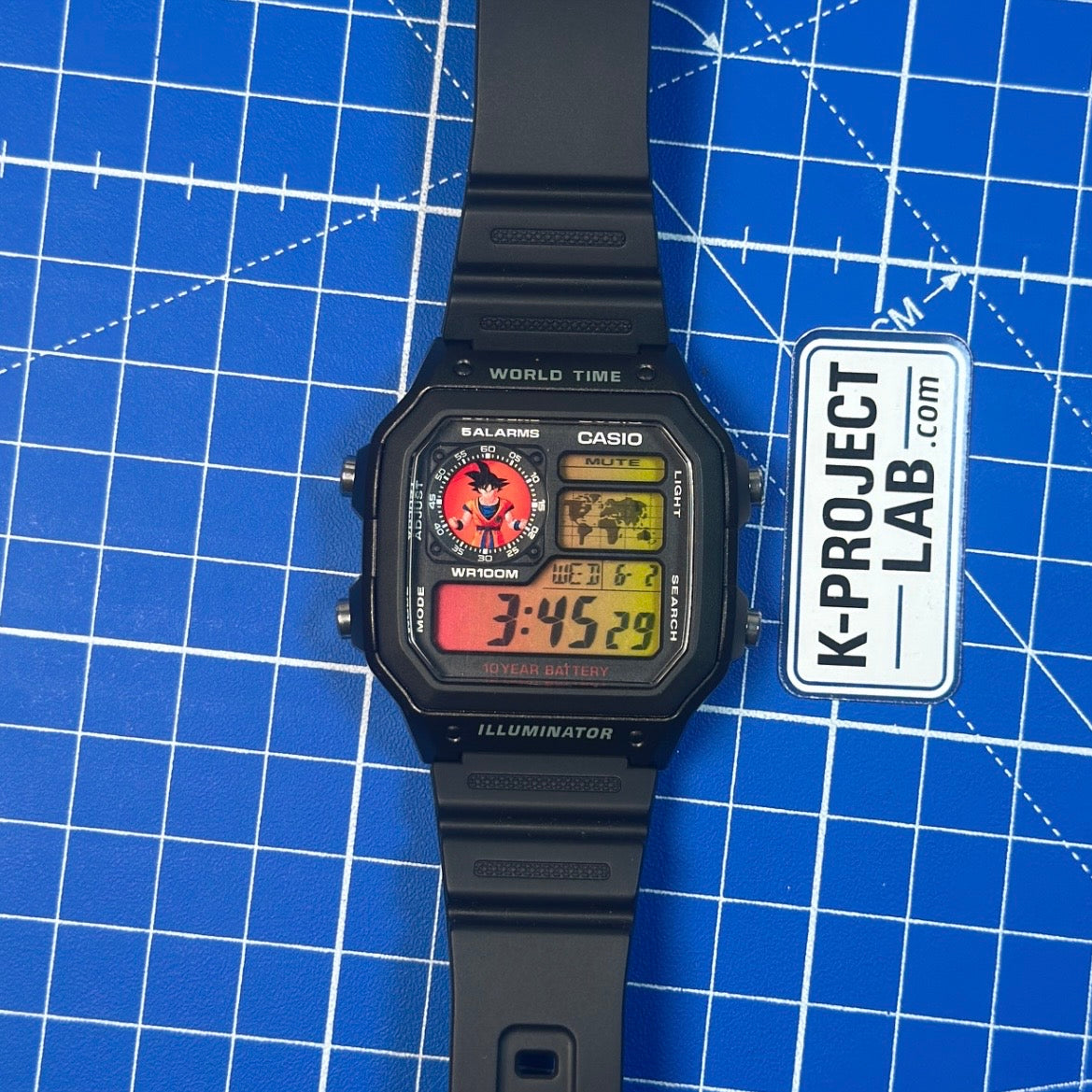 Casio AE-1200 Saiyan Signal in schwarzem Resin mit ausgelegtem Armband auf blauer Fläche von K-Project Lab