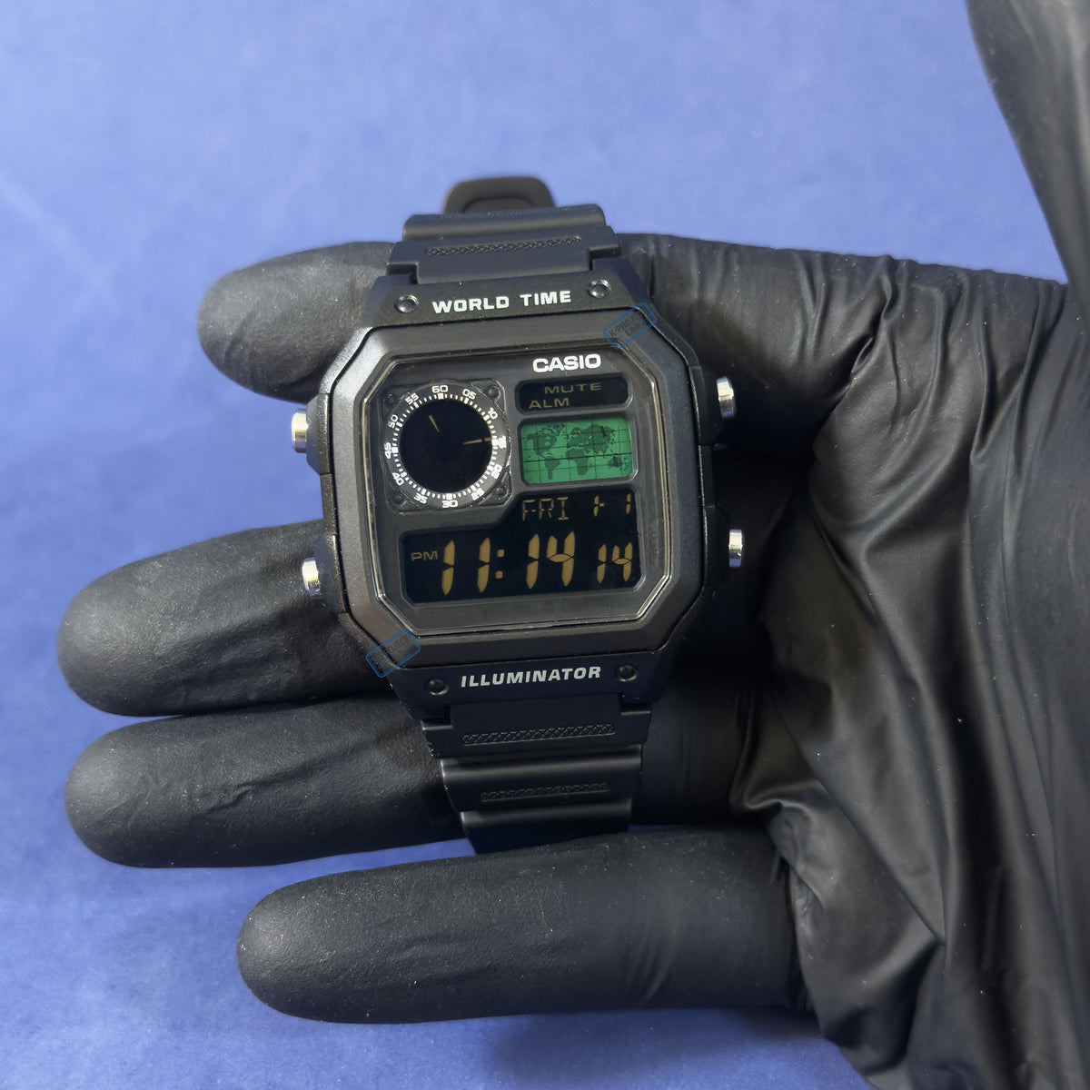K-Project Labin Casio AE-1200 Obsidian Grid mustana hartsina, hansikkaassa kädessä, vihreä ja meripihkanvärinen näyttö