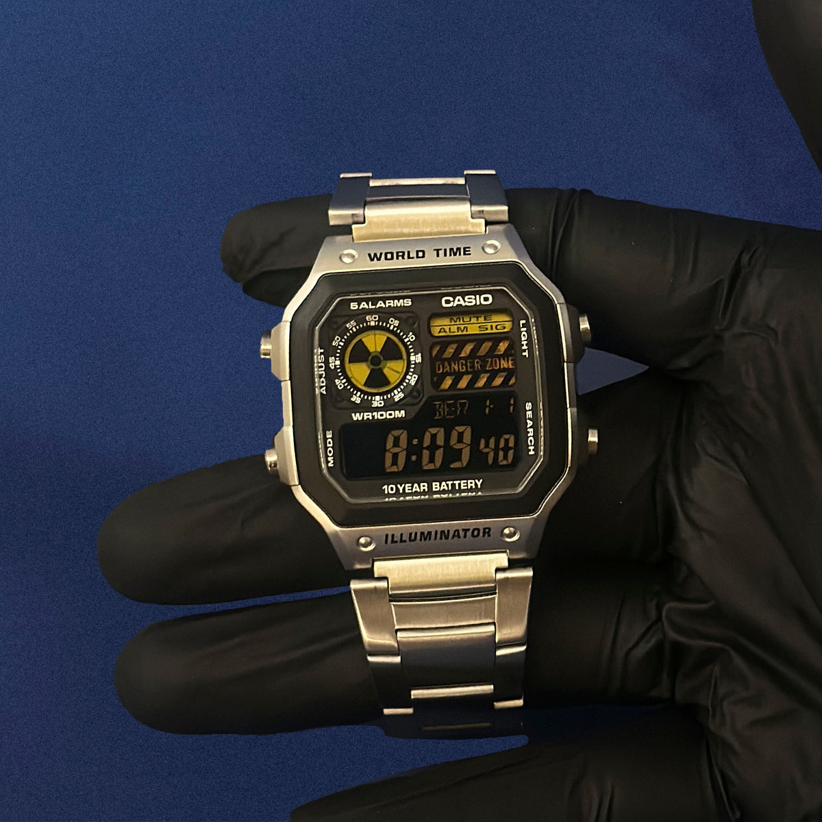 Casio AE-1200 Reactor Sector in Stahl in schwarzem Handschuh, mit gelben Warnstreifen, von K-Project Lab