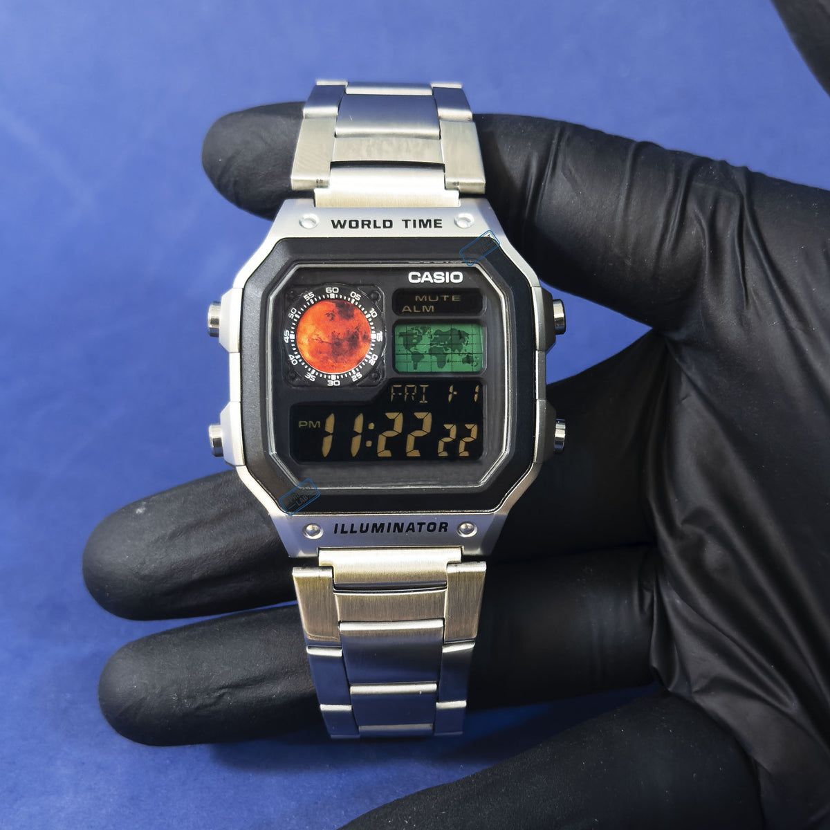 Casio AE-1200 Red Dominion in Stahl in Handschuh gehalten, blauer Hintergrund, von K-Project Lab