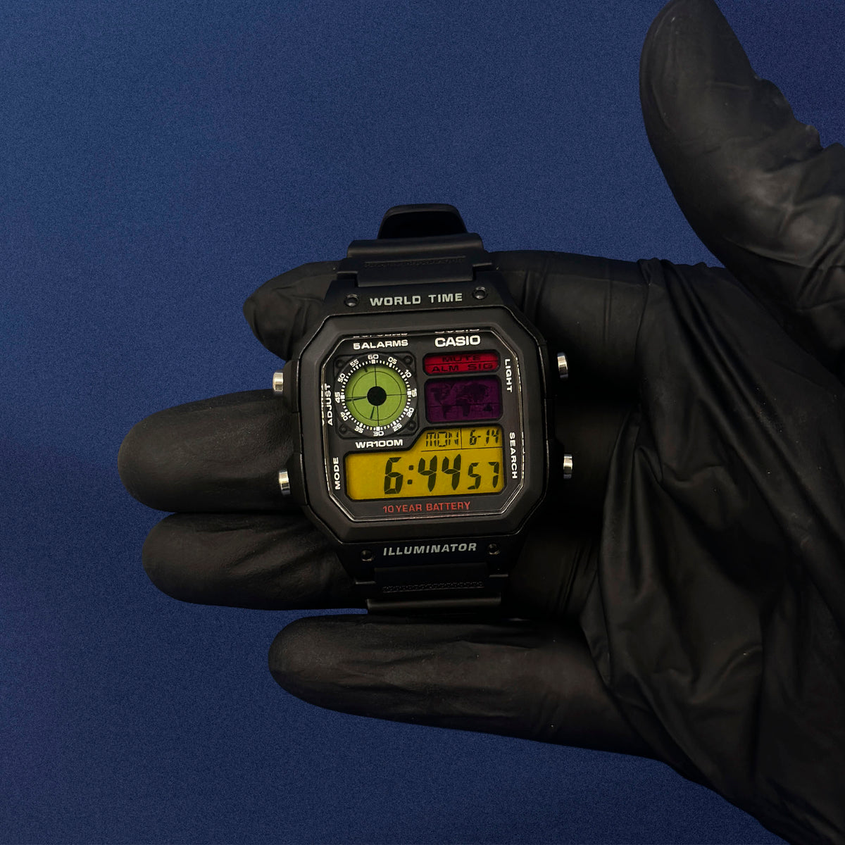 Casio AE-1200 Retro Frequency in schwarzem Resin in schwarzem Handschuh, blauer Hintergrund, von K-Project Lab