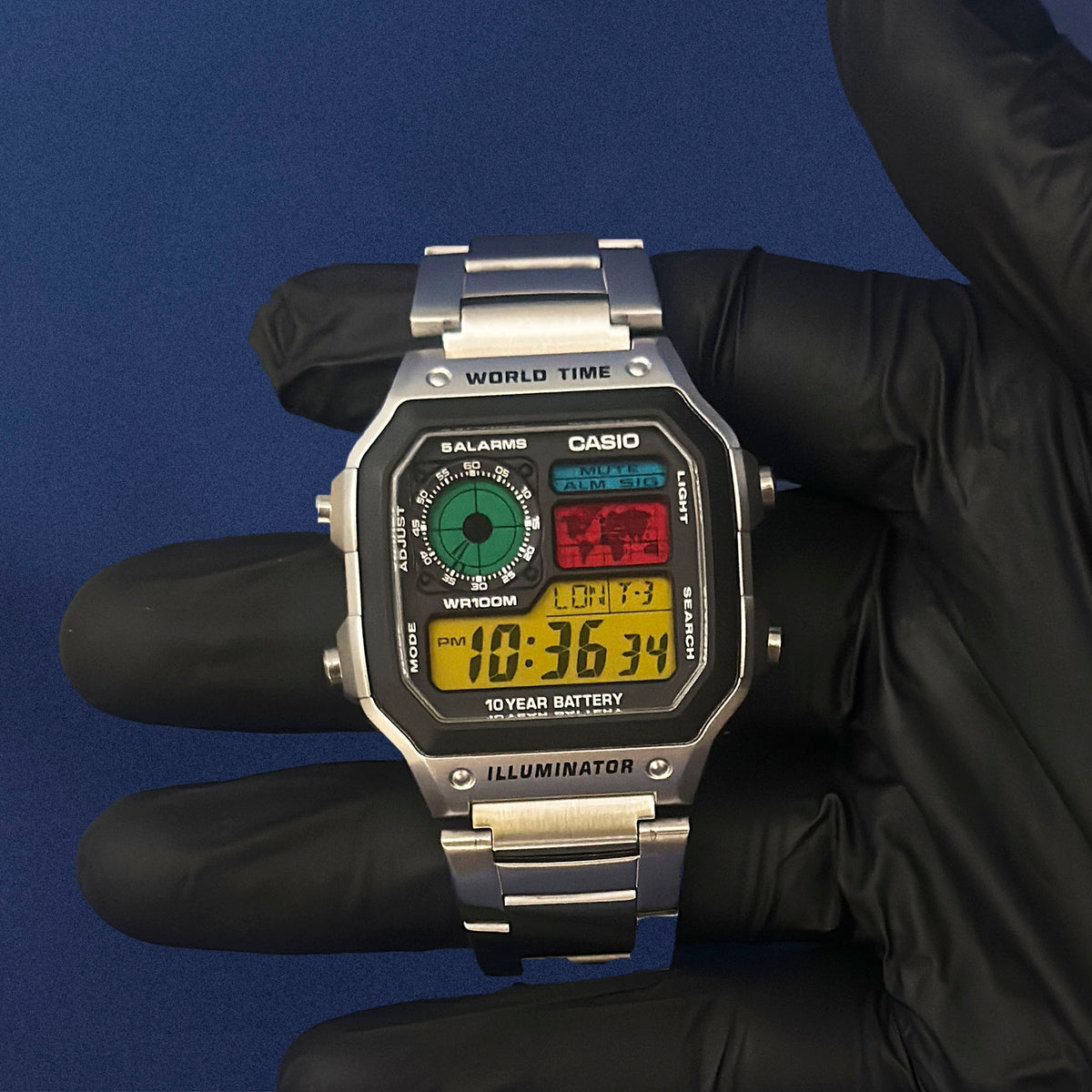 Casio AE-1200 Retro Console in Stahl in schwarzem Handschuh, Detail des mehrfarbigen Displays, von K-Project Lab