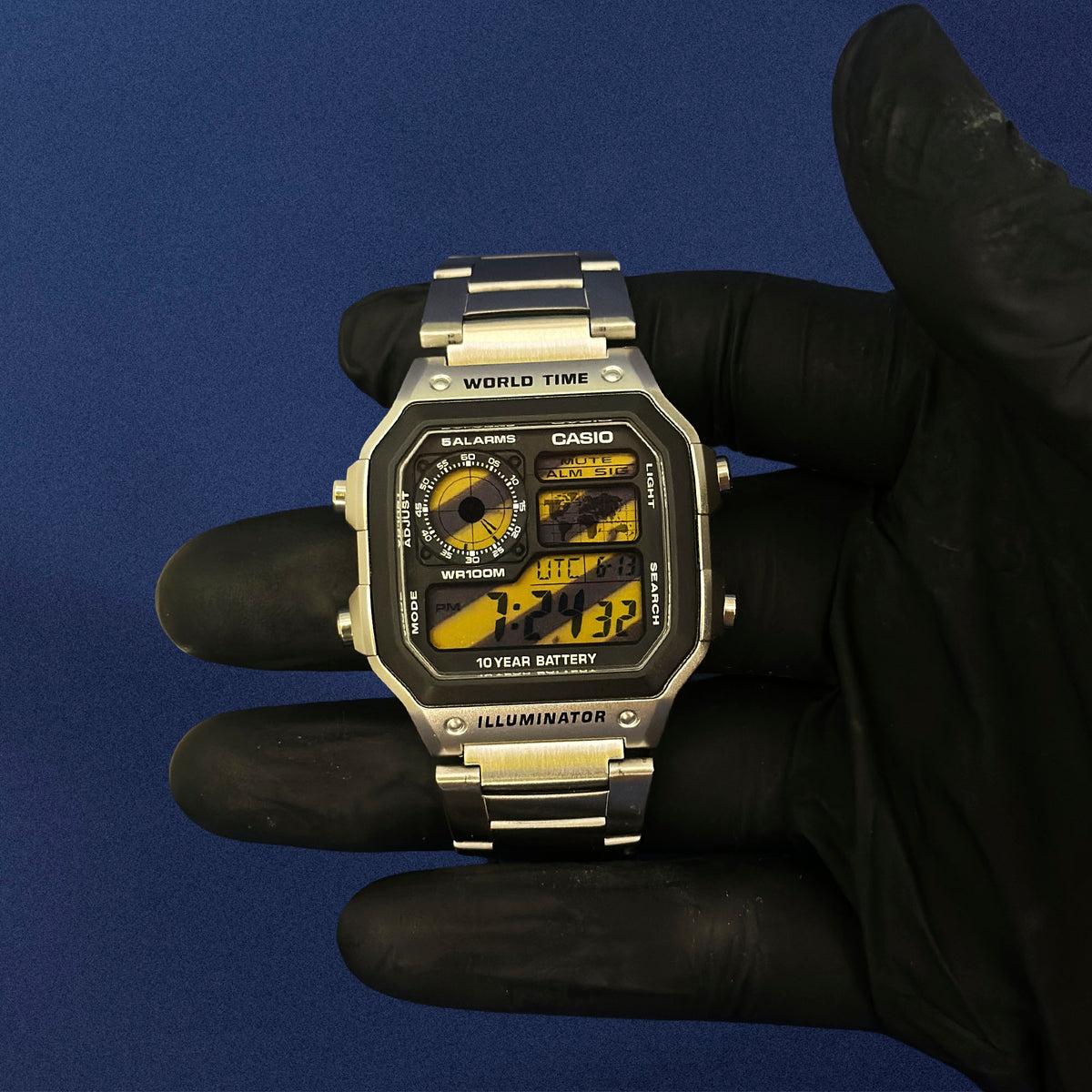 Casio AE-1200 Sector 07 Hazard in Stahl, in schwarz behandschuhter Hand, gelbe Karte im Display, von K-Project Lab