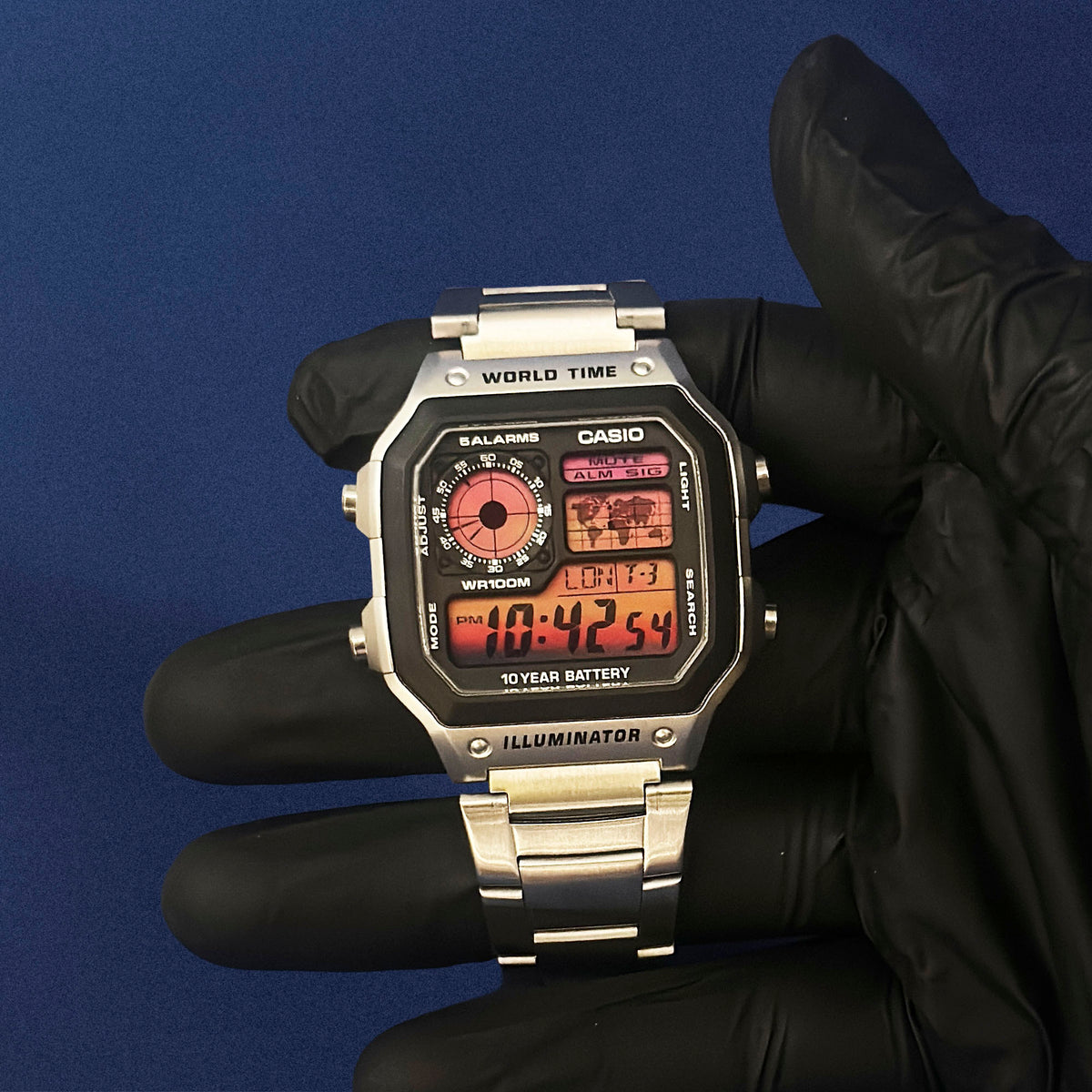 Casio AE-1200 Sunset Horizon in Stahl in schwarzem Handschuh, rot-oranger Verlauf im Display, von K-Project Lab